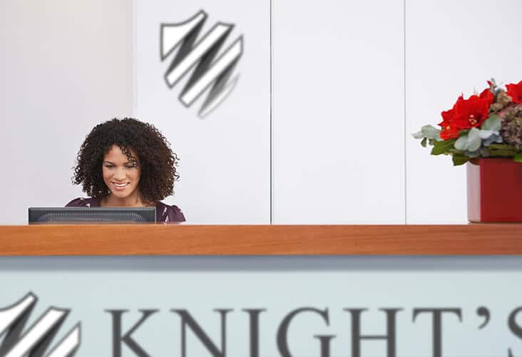 A receptionist sits at her Knight's Cleaning desk